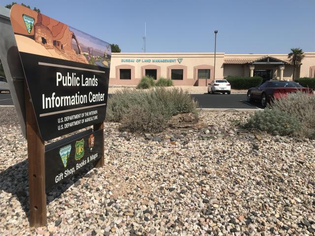 Sign that says Public Lands Information Center with a building in the background that has the words Bureau of Land Management on it