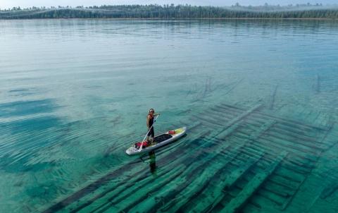 A paddleboarder explores a shipwreck off Thunder Bay Island in Lake Huron
