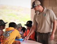 BLM Park Ranger Carty Carson points out the rock art identification to the students.