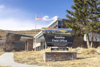 Outside of Rawlins Field Office with the sign in front of the building