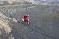 Dirt bike rides the gray clay in the Henry Mountains Fremont Gorge TMP area.