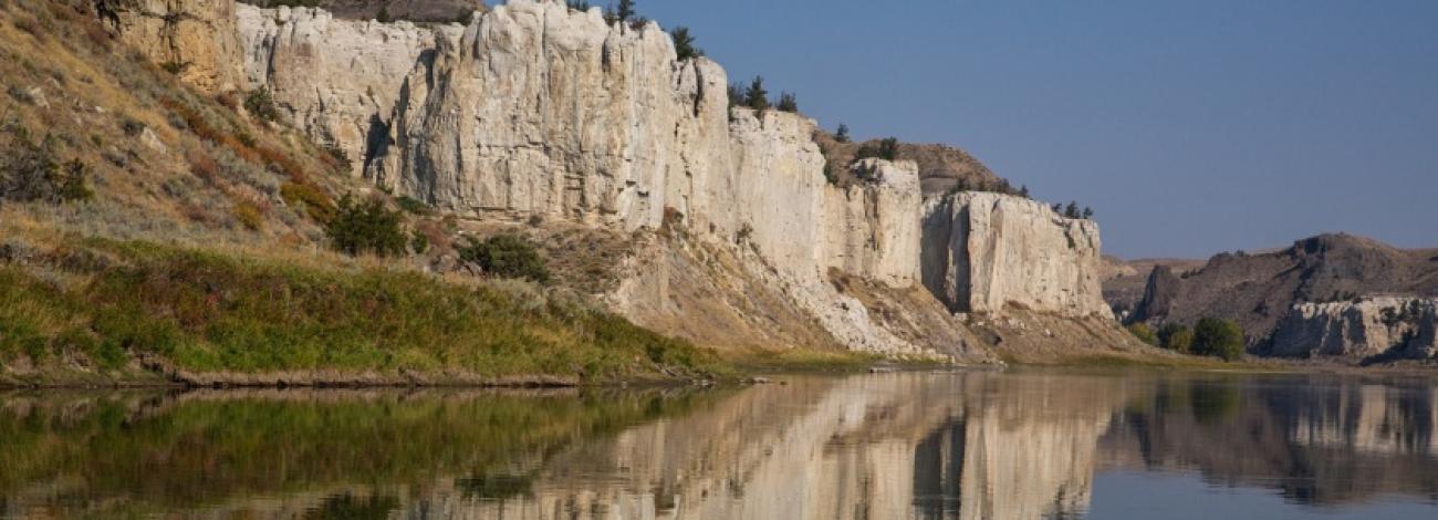 The majestic cliffs of Upper Missouri Breaks National Monuments reflected in the Missouri River. Photo by Bob Wick.
