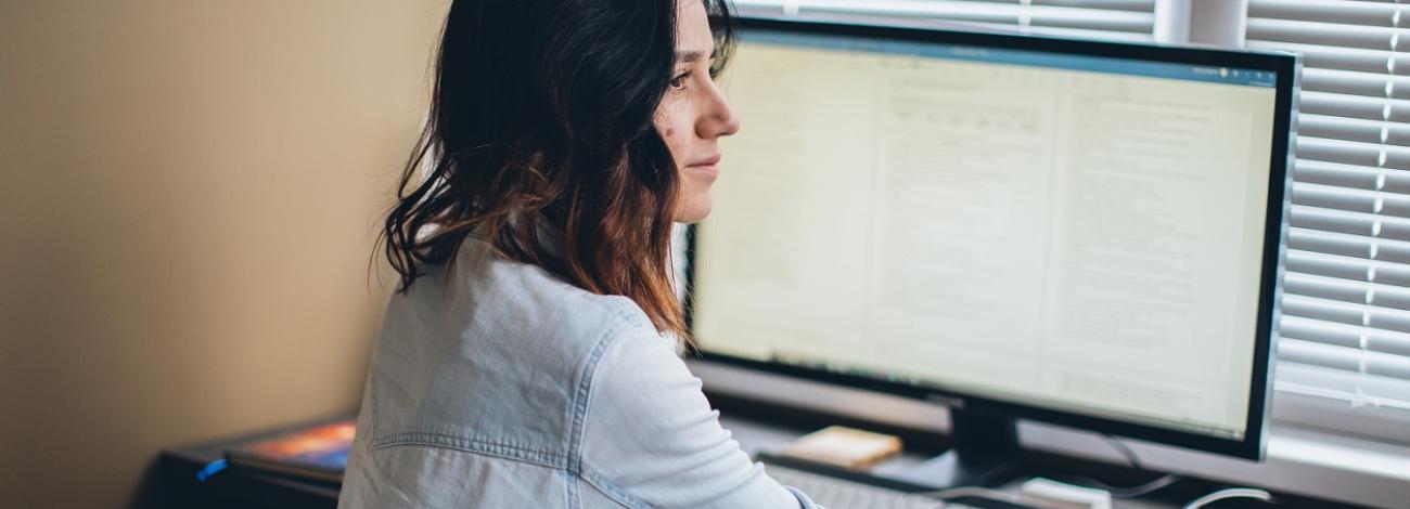 photo of person working in front of computer monitor