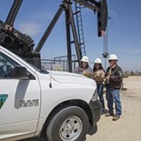 BLM workers in front of a pump jack. 