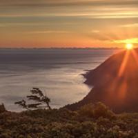 The sun sets over the ocean just behind a mountain on the coast of California.  Photo by Bob Wick, BLM.