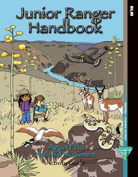 Cover of Junior Ranger handbook showing two children with a canyon and stream in the background. There is a rattlesnake on the rock nearby, a raptor, and some pronghorn antelope.