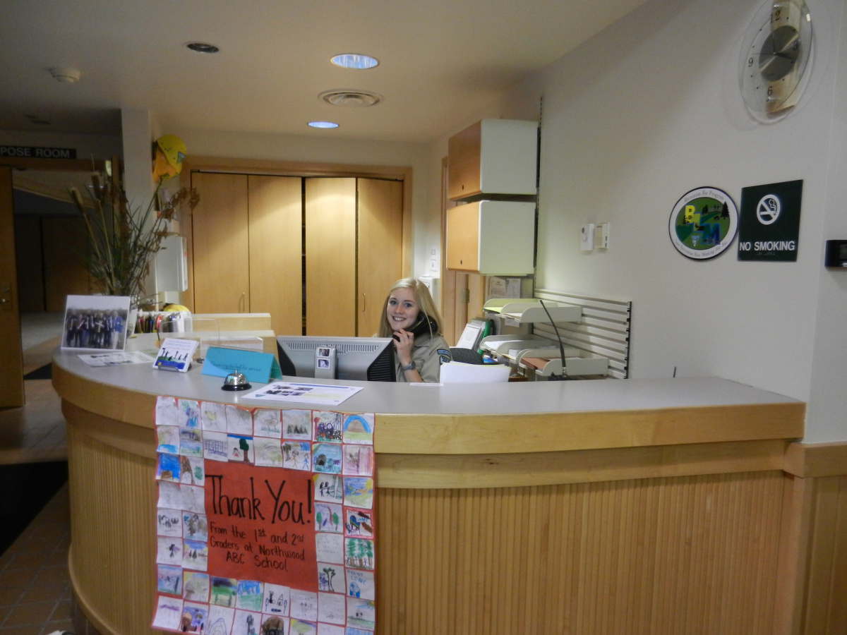 Employee behind the front desk of an office answering the phone