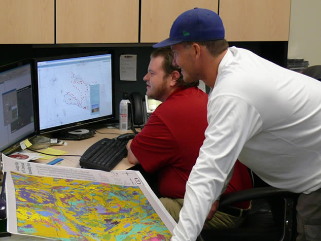 GIS Specialists working on data and maps at desk