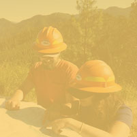 Two people reading a map which is on top of a pickup truck hood