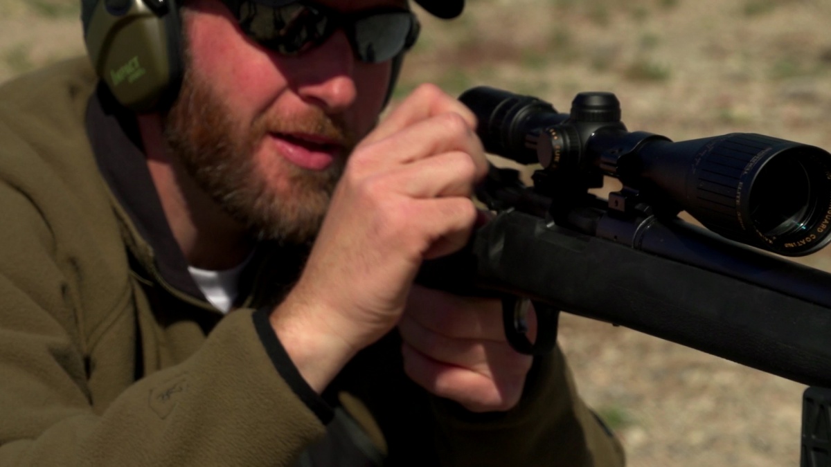 A man shoots his gun in the West Desert.