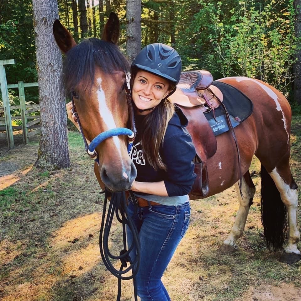 Woman with horse head in her arms. 