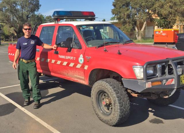 Firefighter Adam Kohley standing next to a training support truck