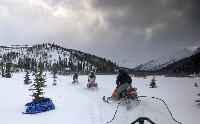 A rescue team riding snow machines