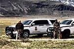 The BLM Ranger K-9 Teams in their vehicles lined up for a photo with majestic mountains in the background