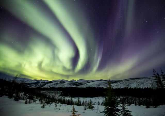 Aurora over a hilly landscape