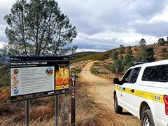 A BLM pickup truck next to a BLM informational sign. Photo by Mike Chiodini, BLM.