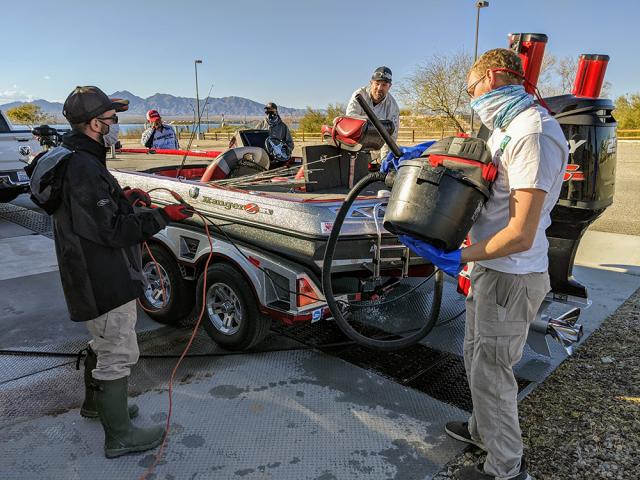 people clean a motor boat on a trailer