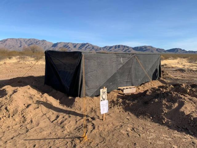 a large square mesh structure in a desert landscape