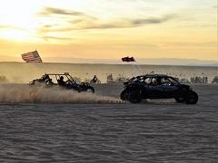 Two off-road vehicles race at sunset at Imperial Sand Dunes. Photo by Eric Coulter, BLM.