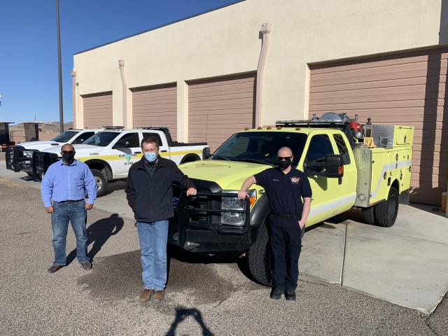 Members of the Colorado River District and Pinion Pine Fire Department stand in front of a fire engine. 