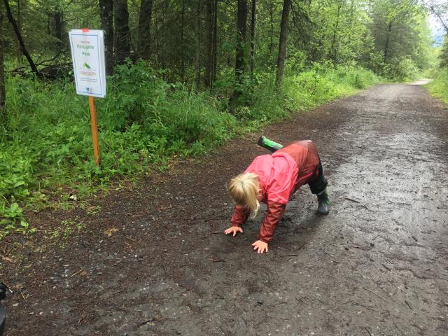 Toddler bending over on the trail like a porcupine