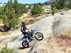 A dirt bike races up hill. Photo by Marisa Williams, BLM)