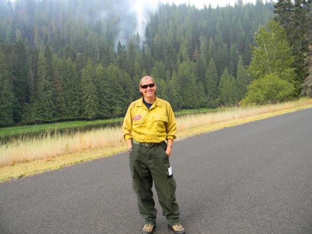Carmen standing on pavement in nomex fire pants and yellow fire shirt