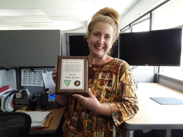 Kerry holding an award plaque