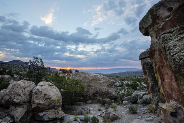 Scenic view across rock formations with cloudy sunset background