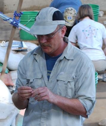 Kirk Halford examines an artifact at the Cooper's Ferry archaeological site in the lower Salmon River canyon of western Idaho.