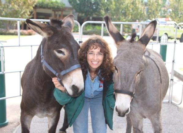 Woman standing with a burro on each side