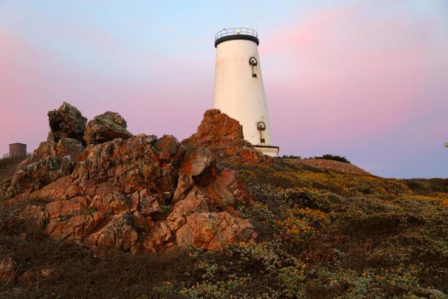 Light house with rocks in the foreground.