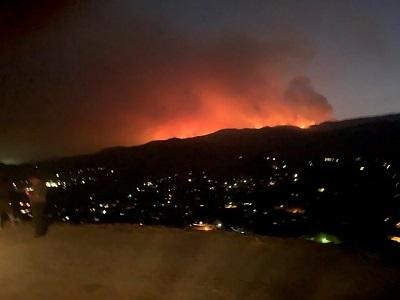 Fire rises over a hill.