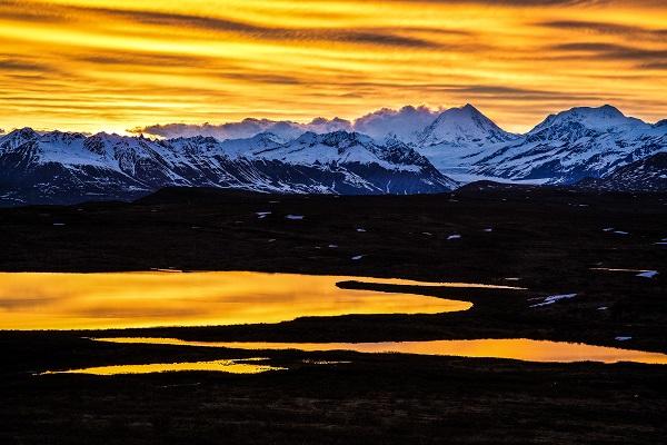 Bob says: "This photo taken in Alaska was one of my favorite photo experiences. In the lower 48 a twilight glow after sunset lasts about 15 or 20 minutes. Here along the Denali Highway, I sat up all "night" and watched the twilight continue for several hours before the sun rose. View is of Mount Hayes: At 13,800 feet it is one of the highest mountains on BLM-managed lands." (Photo by Bob Wick)
