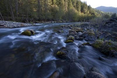 A river flows the forest as the sun sets. Photo by Bob Wick, BLM