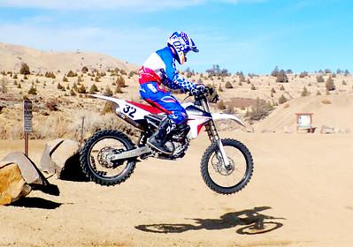 Dirt bike going over a jump in the high desert. Photo by Tara Alexander, BLM.