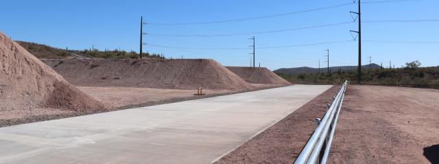 a long concrete pathway with large earthen berms