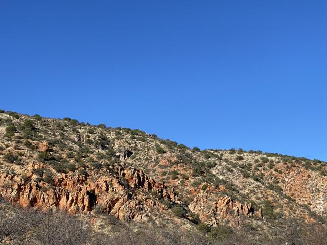 looking across at a rocky area with many green trees dotting the hillsides