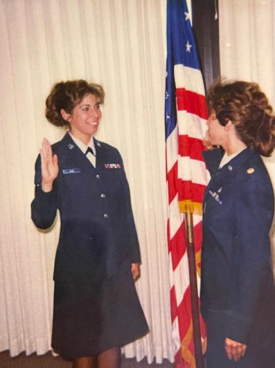 Two women standing with hands raised