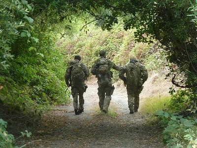 Three rangers walking down a trail.