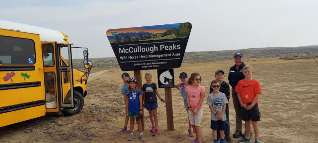 Kids posing in front of herd management area sign