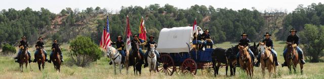 Cavalry on horseback and a covered wagon.