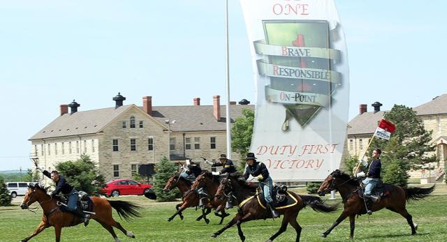 Mounted cavalry running on grass.