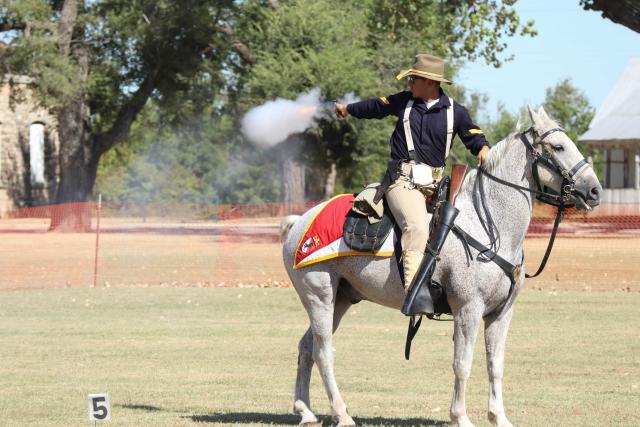 Guy on horseback shooting revolver. 