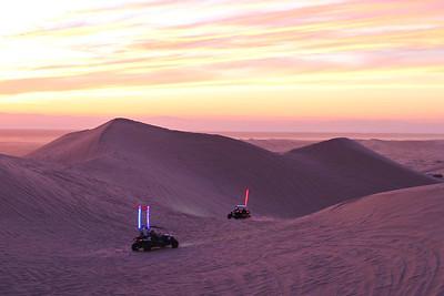 Racers in sand dunes at night.