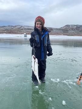 Child hold fish after ice fishing at Otter Creek Reservoir. Devin McLemore, BLM-Utah Color Country District, Richfield Field Office.