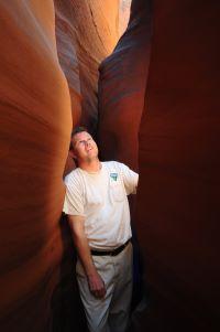 BLM employee standing in the narrow Spooky Gulch Slot Canyon. 