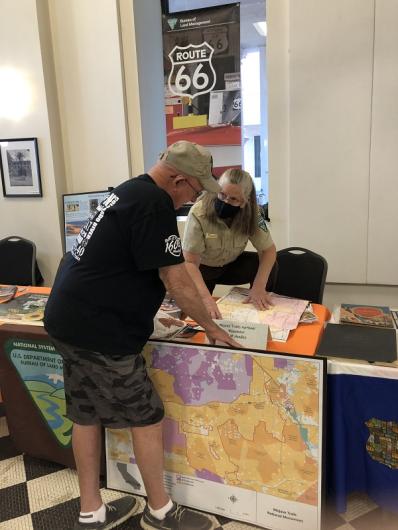 A woman showing a map to a visitor at a BLM booth