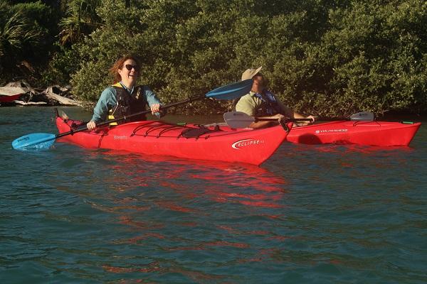 BLM Director Tracy Stone-Manning and Peter DeWitt paddling in red kayaks on the river.