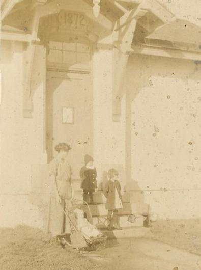 A young Marguerite her in stroller, her mother, and her siblings on the steps of the lighthouse.